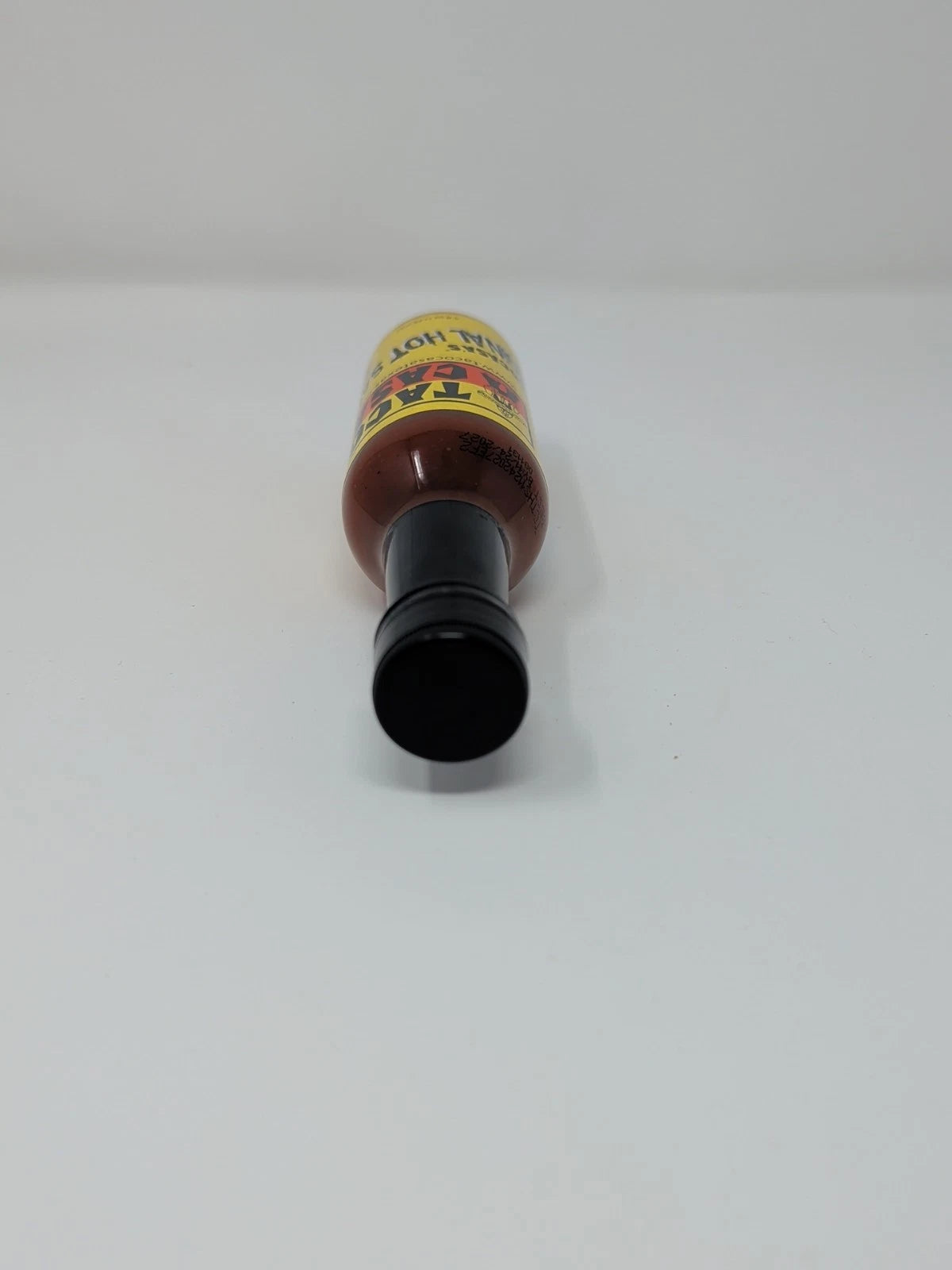 Hot sauce bottle with a yellow label on a white background