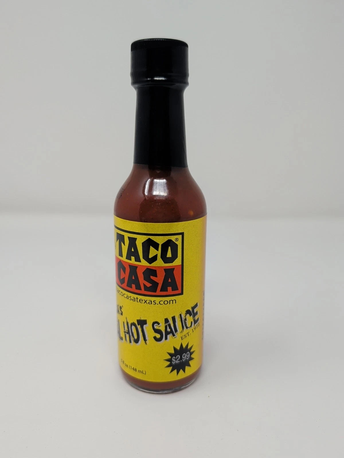 Bottle of Taco Casa hot sauce with a yellow label on a white background