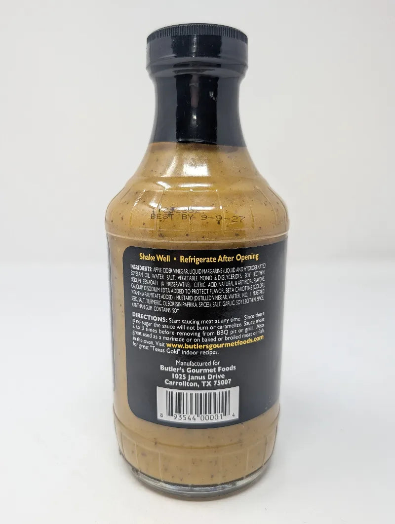Side view of a bottle of Butler's Texas Gold Gourmet BBQ Sauce on a plain white background featuring an ingredients list. The bottle is filled with a golden-brown sauce and features a black label with white and yellow text.