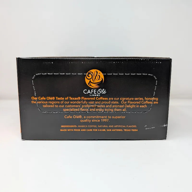 Side view of a box of Cafe Ole by HEB Houston Blend Medium Roast coffee pods, featuring a black and orange design with an ingredients list.
