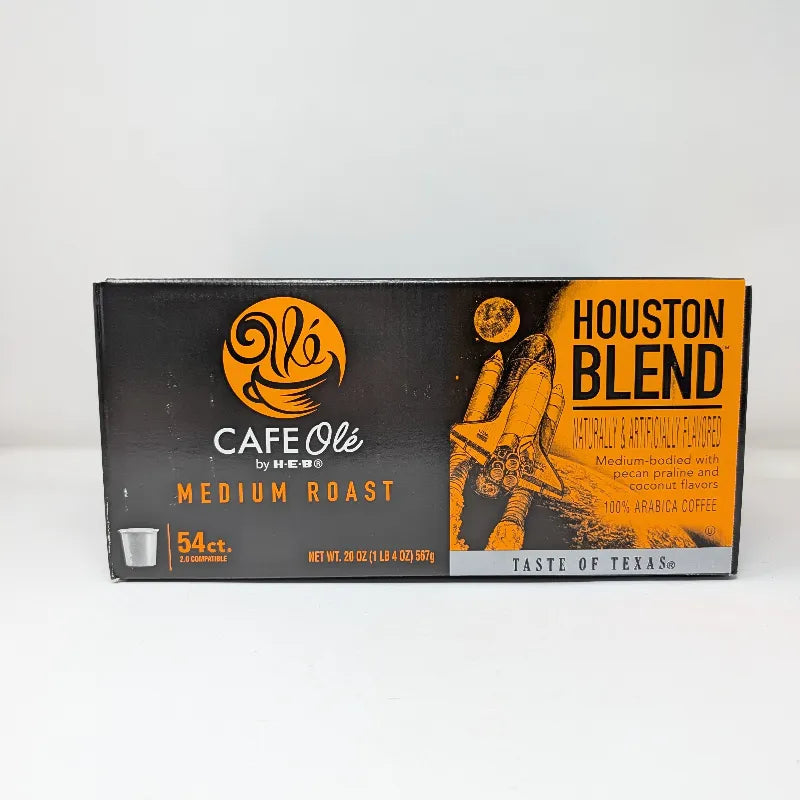 Side view of a box of Cafe Ole by HEB Houston Blend Medium Roast coffee pods, featuring a black and orange design with a space shuttle graphic and text indicating 54 count.
