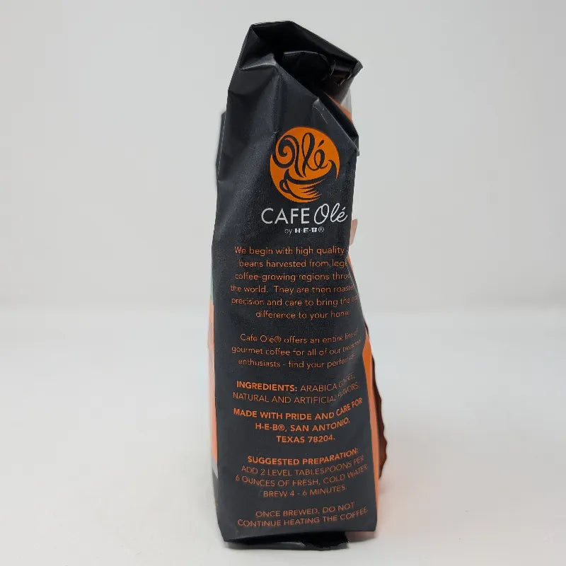 Side view of a 12 ounce bag of Cafe Ole by HEB Houston Blend Decaffeinated Ground Coffee. It features an orange and black color scheme with an ingredients list on a white background.