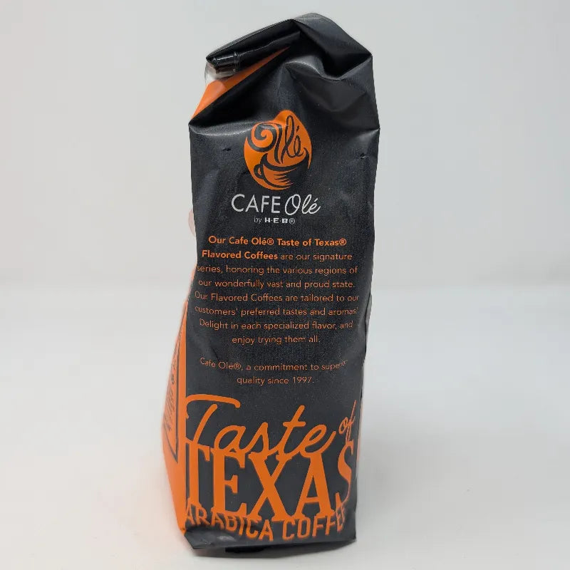 Side view of a 12 ounce bag of Cafe Ole by HEB Houston Blend Decaffeinated Ground Coffee. It features an orange and black color scheme on a white background.