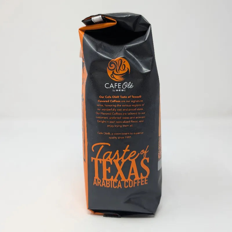 Side view of a 12 ounce bag of Hub City Blend medium roast ground coffee featuring an orange and black design scheme on a white background.