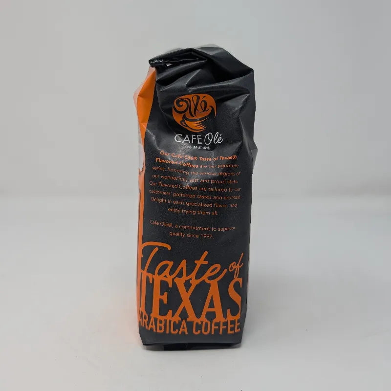 Side view of a 12 ounce bag of Cafe Ole by H-E-B Rio Grande Especial ground coffee featuring an orange and black color scheme on a plain white background.