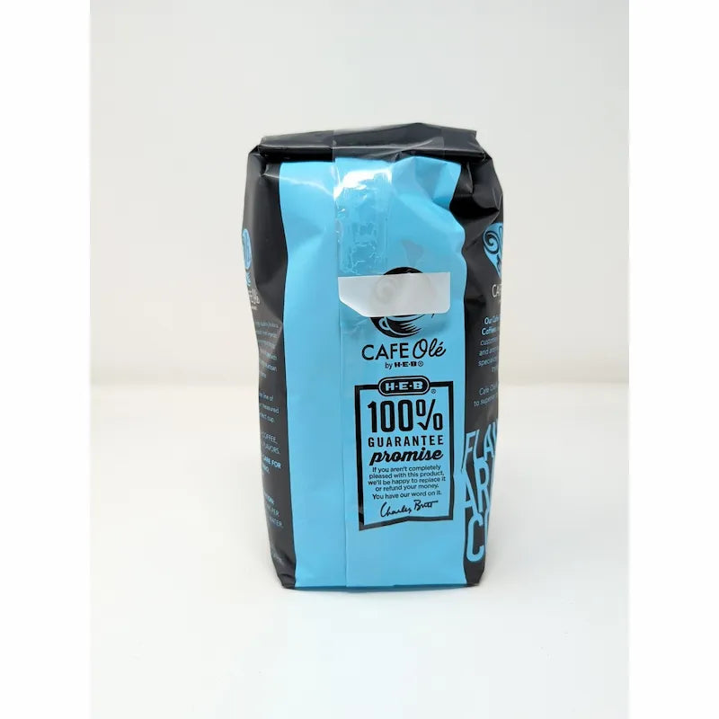 Back view of a 12 oz bag of Cafe Olé Texas Pecan ground coffee, medium roast, in a black bag with a blue label on a white background.