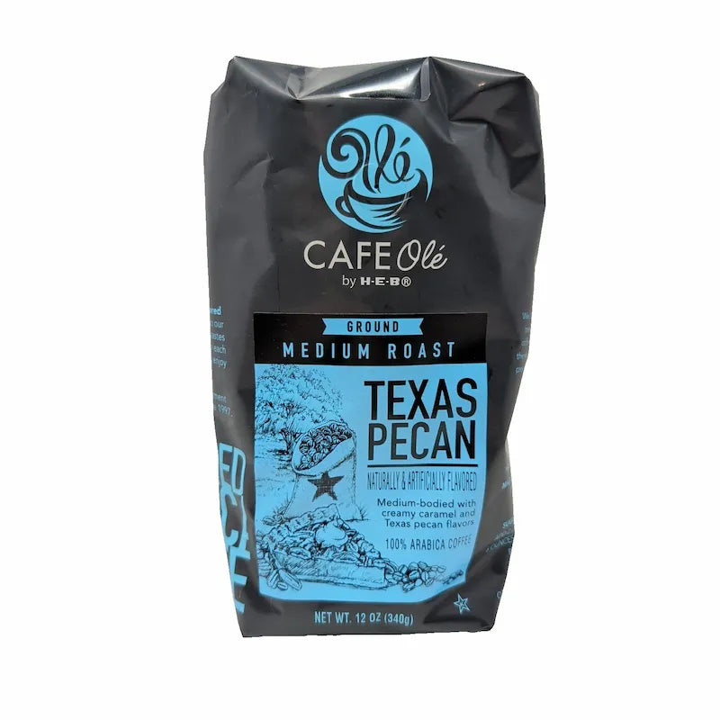Front view of a 12 oz bag of Cafe Olé Texas Pecan ground coffee, medium roast, in a black bag with a blue label on a white background.