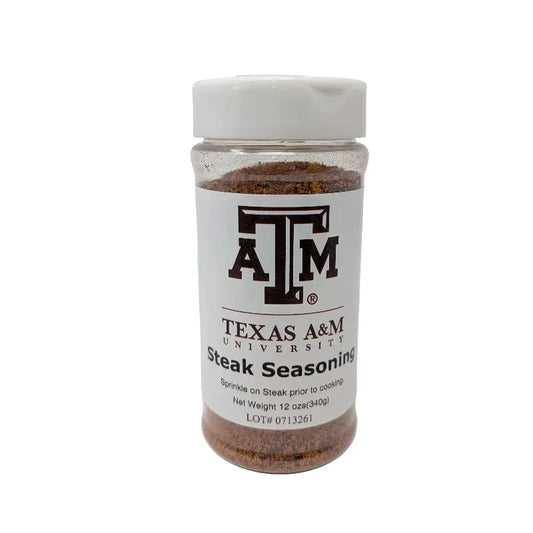 Front view of a clear plastic bottle of Texas A&M University Steak Seasoning with a white cap and white label, containing brown seasoning powder, on a white background.