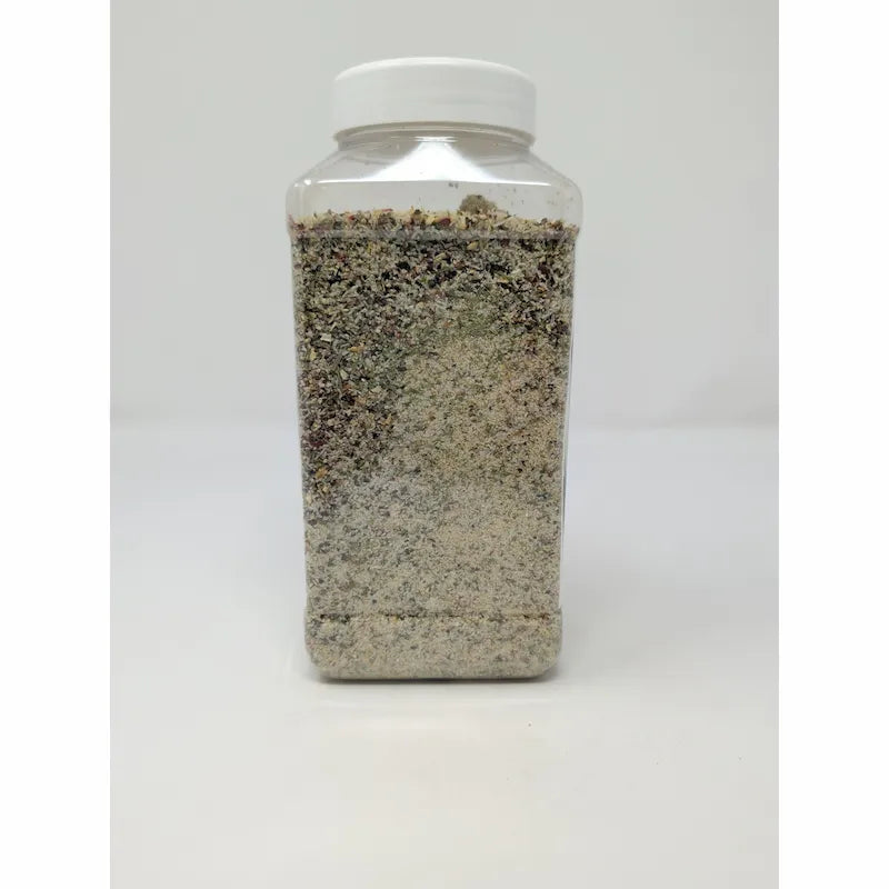 Side view of Uncle Chris Gourmet Steak Seasoning in a clear plastic shaker bottle with a white cap, on a white background.