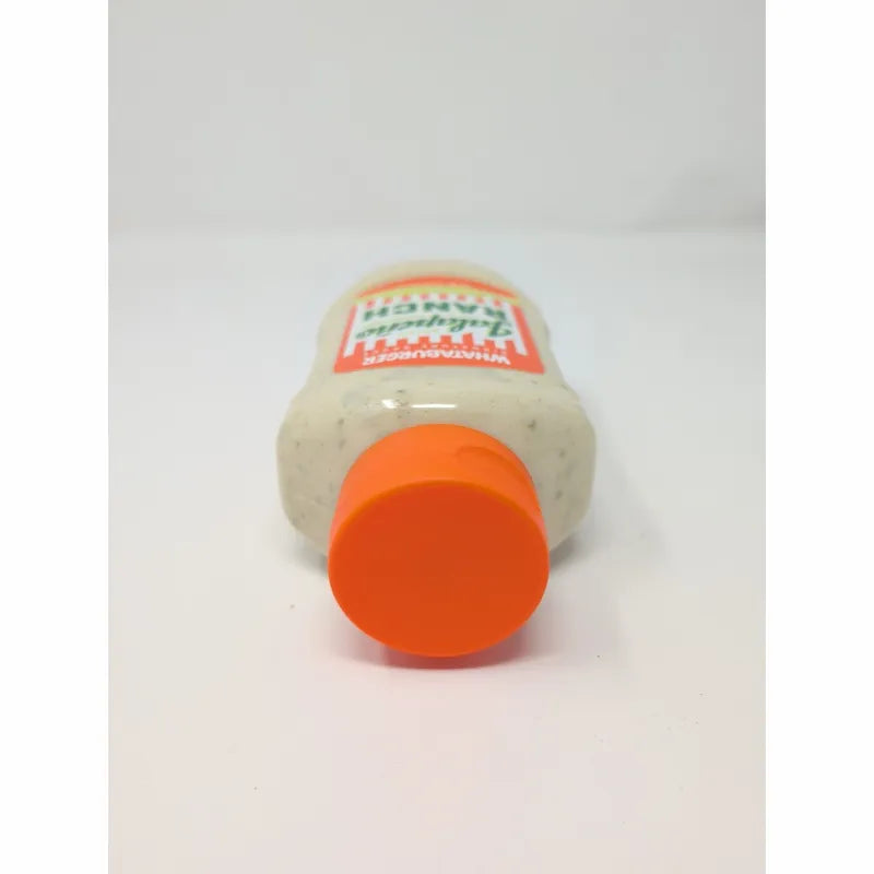 Top view of a  bottle of Whataburger Signature Sauce with an orange cap and a white sauce inside.
